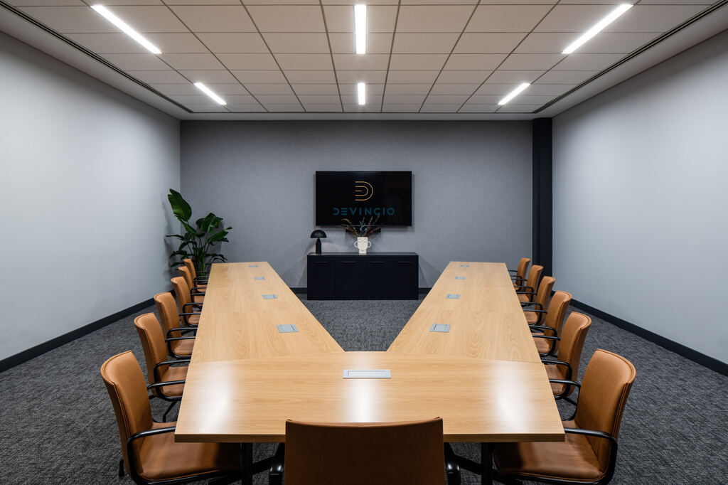 Conference room with an open wood table layout and wall display