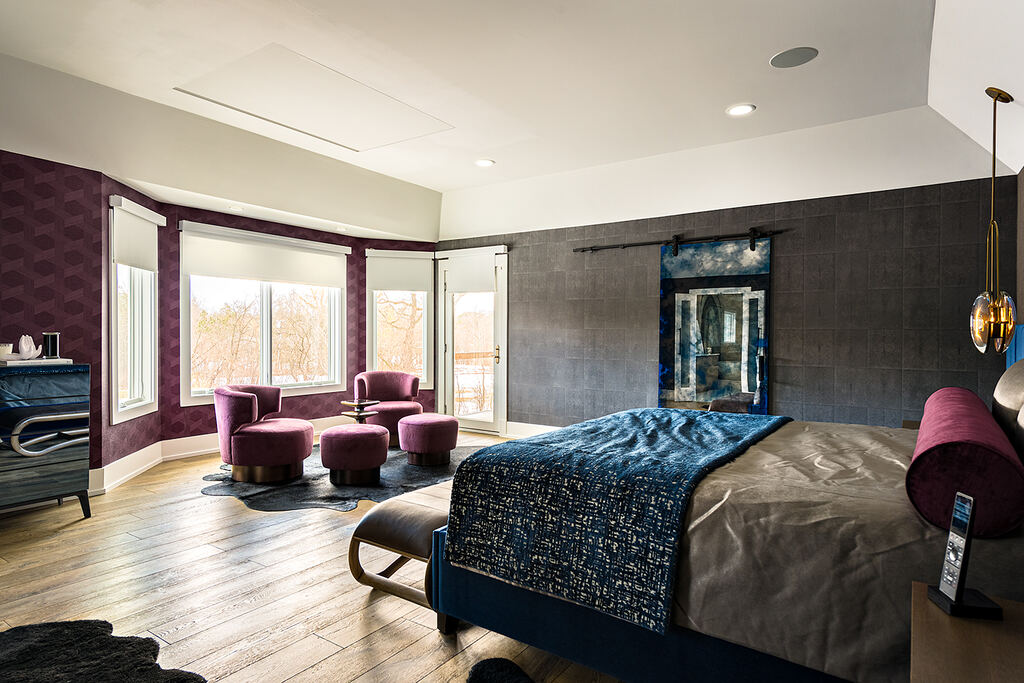 Bedroom with an upholstered bed, lounge seating, windows, and a recessed ceiling panel