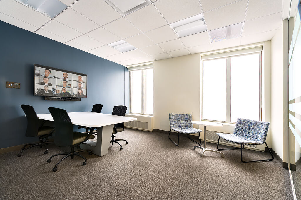 Small meeting room with a wall display and compact conference table